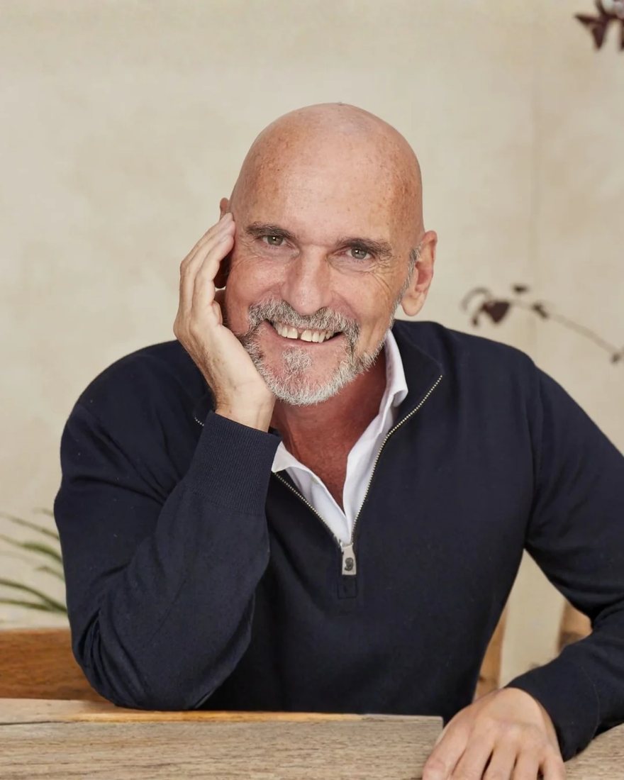 Le Dr Christophe Fauré, psychiatre français, souriant, accoudé à une table en bois